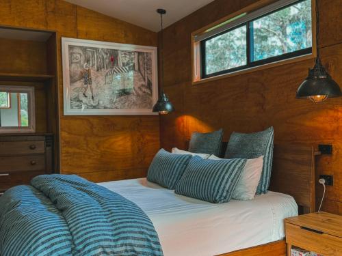 a bedroom with a bed with blue and white pillows at The Little Seed in Franklin