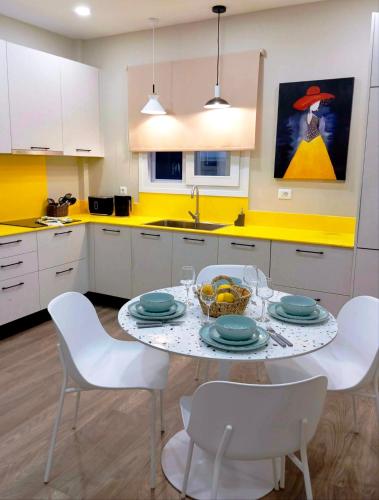 a kitchen with a table with plates and bowls of fruit on it at Obassys View in Faraklata