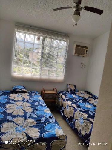 a bedroom with two beds and a window at Casa de Mar in Acapulco