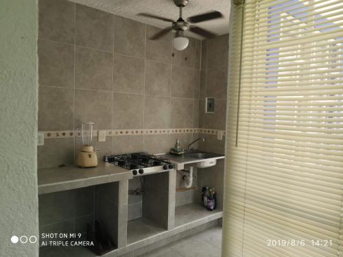 a kitchen with a stove and a sink and a window at Casa de Mar in Acapulco