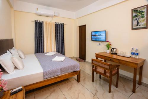 a bedroom with a bed and a desk with a desk at Park View Residency - Guest House Near Sree Padmanabhaswamy Temple in Trivandrum