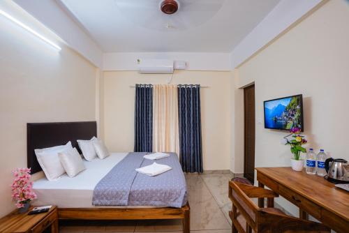 a bedroom with a bed and a desk and a television at Park View Residency - Guest House Near Sree Padmanabhaswamy Temple in Trivandrum