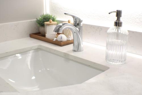 a white sink in a kitchen with a faucet at The Drop Inn NWA Basecamp in Rogers