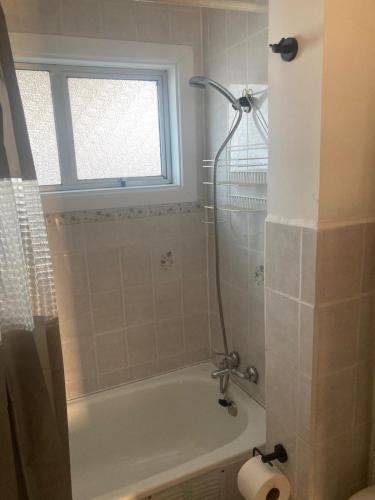 a bathroom with a bath tub and a window at Casas Rabad in Punta Arenas