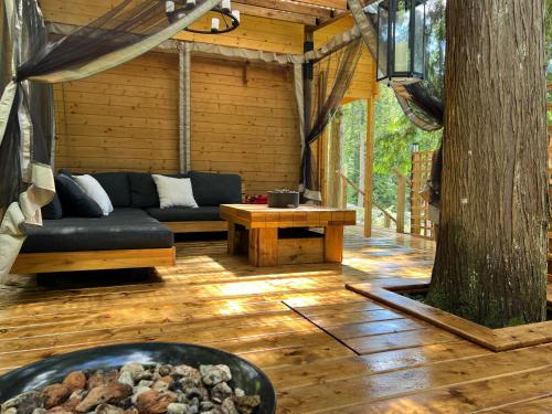 a screened in porch with a couch and a table at Creekside Bunkies in Roberts Creek