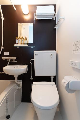 ein Badezimmer mit weißer Toilette und Waschbecken in der Unterkunft からつホテルQueendom in Karatsu