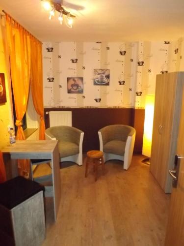 a room with two chairs and a table and a wall with pictures at Haus Oberkassel in Bonn