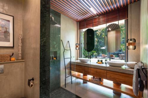 a bathroom with two sinks and a large mirror at San Michele Villa in Dalung