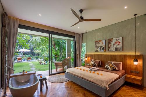 a bedroom with a large bed and a tub at San Michele Villa in Dalung