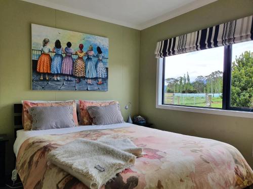 a bedroom with a large bed with a painting on the wall at Kepler Mountain View in Manapouri