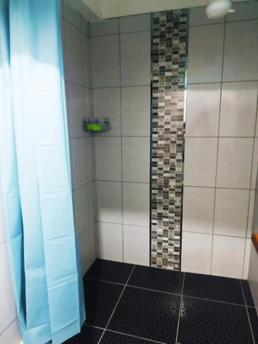 a bathroom with a shower with a black tile floor at Shekina Huaraz Departament in Huaraz