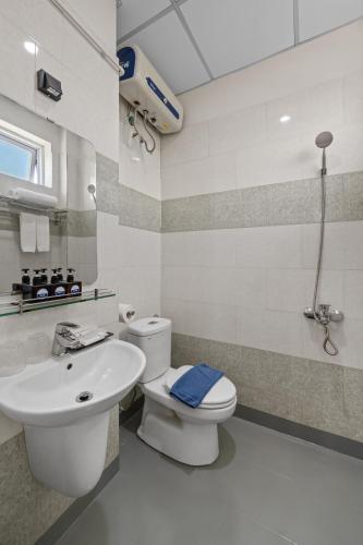 a bathroom with a white toilet and a sink at Vorya Hotel Danang Beach in Danang