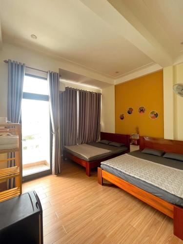 a bedroom with two beds and a window at TRI'S Homestay in Quy Nhon