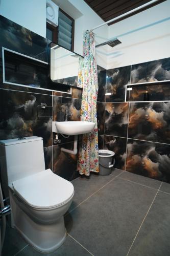 a bathroom with a toilet and a sink at Eden Park Resorts in Vuyyūru