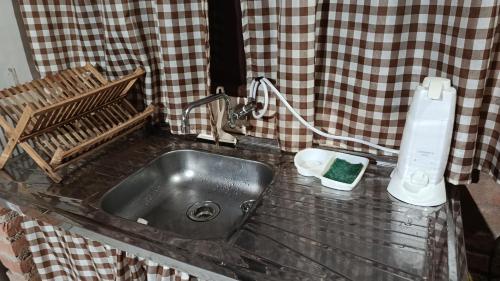 a kitchen counter with a sink and a soap dispenser at Chalé Mandala de Pedra in São Thomé das Letras