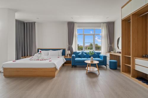a hotel room with a bed and a blue couch at Vorya Hotel Danang Beach in Danang