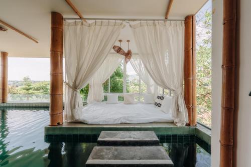 a bedroom with a bed and a pool of water at Pupah Kanna Pua-ปู๋ ป๋าล์ คันนา ปัว in Pua