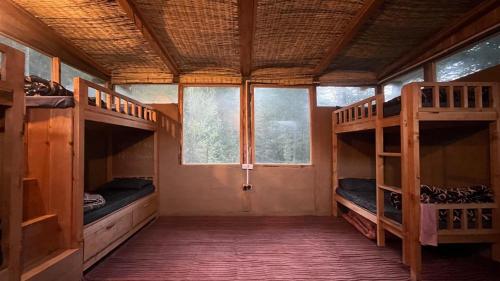 a room with two bunk beds and a window at Alex Tribe Cafe and Funstay in Sainj