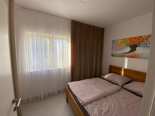 a small bedroom with a bed and a window at Apartmany Vir DaRa in Vir