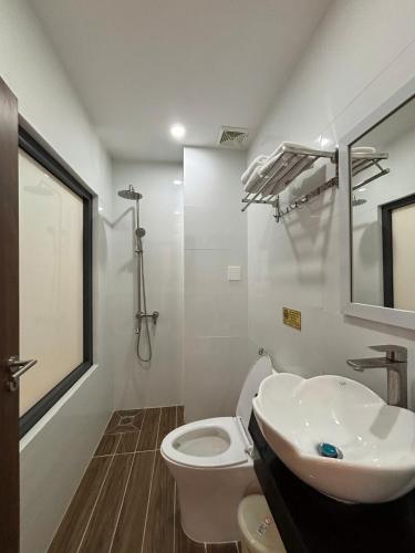 a bathroom with a white toilet and a sink at Khách sạn Vân Nhi 2 in Bạc Liêu