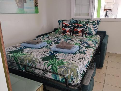 a bed in a room with a bedspread with plants at Kaza LYBS in Fort-de-France