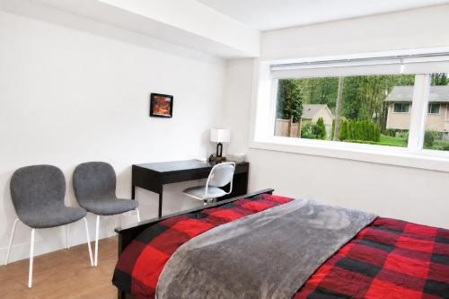 a bedroom with a bed and a desk and two chairs at Centrally Located Modern Suite in North Vancouver