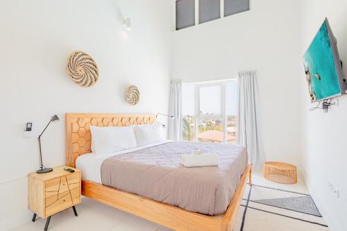 a white bedroom with a bed and a window at Aruba Life 315 in Noord