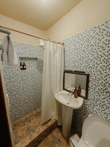 a bathroom with a sink and a toilet and a shower at Zu Suites in San Marcos La Laguna