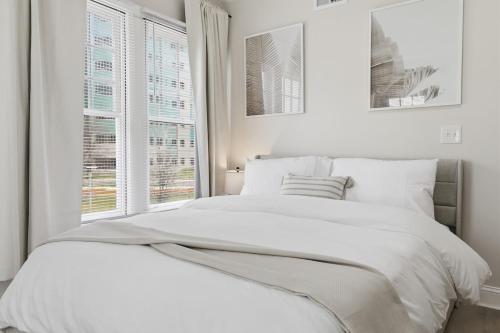 a white bedroom with a large bed and a window at Keifer Suite in Detroit