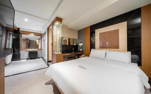 a bedroom with a large white bed and a bathroom at Nowon Luxe in Seoul