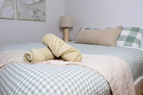 a stuffed animal is laying on top of a bed at Tranquillity On The Promenade in Batemans Bay