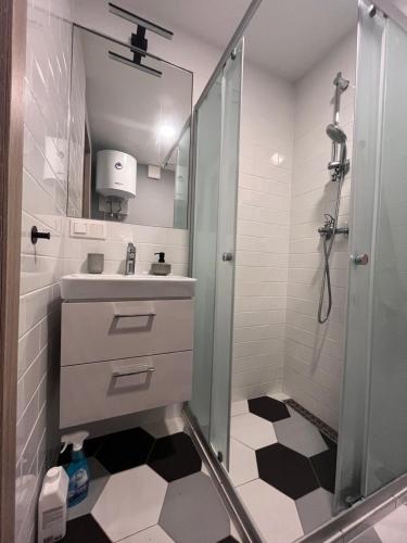 a white bathroom with a shower and a sink at Shells & Pines in Jūrmala