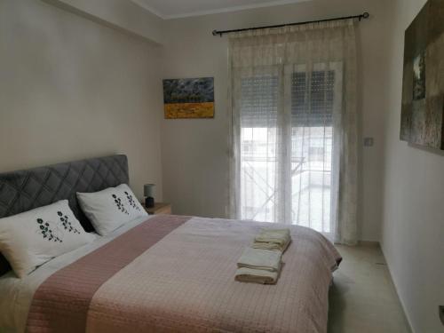 a bedroom with a large bed with a window at Unique Centro Apartment in Kilkis