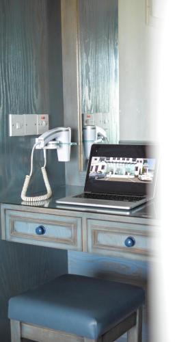 a desk with a laptop computer and a phone at TSANotel in Limassol
