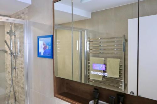 a bathroom with a mirror over a sink at Tranquillity On The Promenade in Batemans Bay