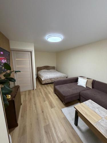 a living room with a couch and a bed at Harmony Apartments Lux in Liepāja