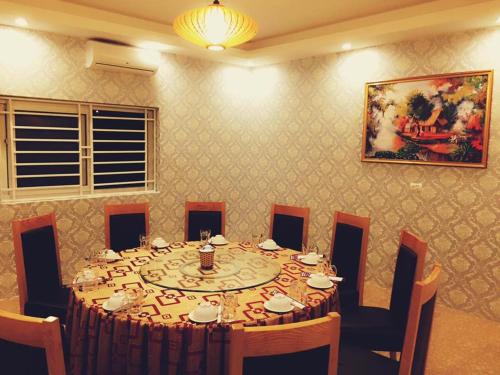 a dining room with a table and chairs and a painting at Binh Minh Dien Chau Hotel in Diễn Châu