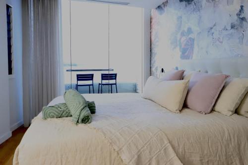 a bedroom with a large bed with a pillow on it at Penthouse On The Promenade in Batemans Bay