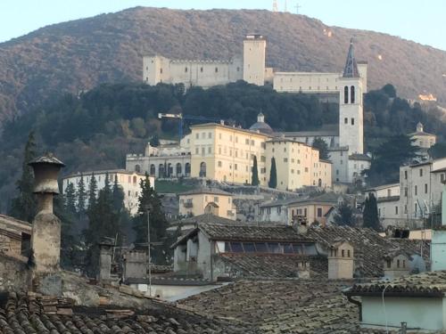 uitzicht op een stad met een berg op de achtergrond bij Sotto i tetti del borgo in Spoleto