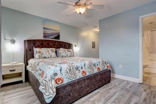 a bedroom with a large bed and a ceiling fan at Surf City Stay - Motel Unit - Walk to Beach in Surf City