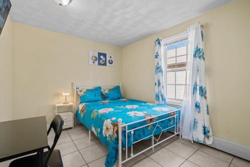 a bedroom with a blue bed and a window at The Public Street Residence in Providence
