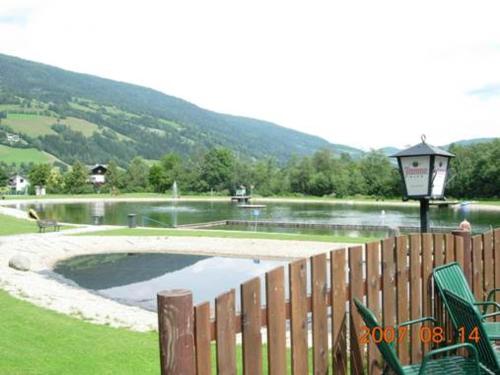 a pond with a lamp and a wooden fence at Da Bräuhauser in Stadl an der Mur
