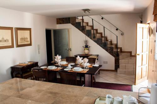 a dining room with a table and chairs and a staircase at Apartment at 34 Columbine Avenue in Johannesburg