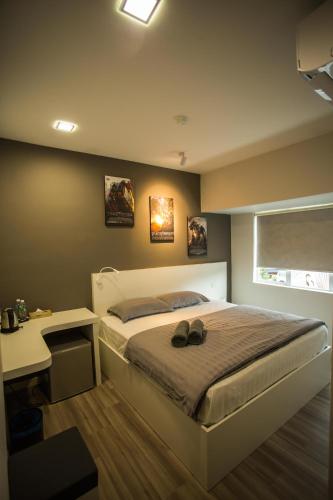 a bedroom with a bed and a desk with shoes on it at Hollywood Hotel in Ipoh