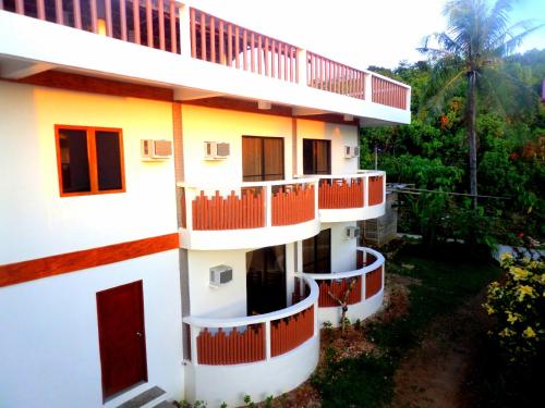 an apartment building with red doors and balconies at Oasis Resort and Spa in Boracay