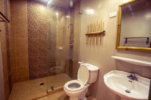 a bathroom with a shower and a toilet and a sink at Oasis Resort and Spa in Boracay
