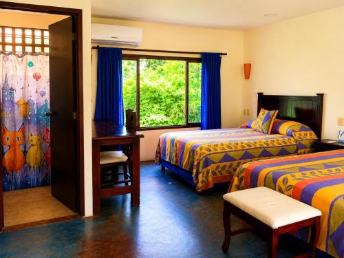 a hotel room with two beds and a window at Los Susurros. Casa in Palenque