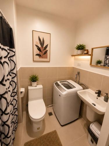 a bathroom with a toilet and a sink at Stylish 1BR Condo @ SM Southmall in Manila