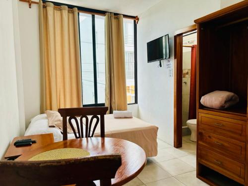 a room with a bedroom with a bed and a table at Suite Economy in Puerto Ayora
