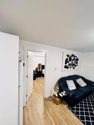 a living room with a black couch and a kitchen at New & Modern Suite in Bristol Riverview in Riverview